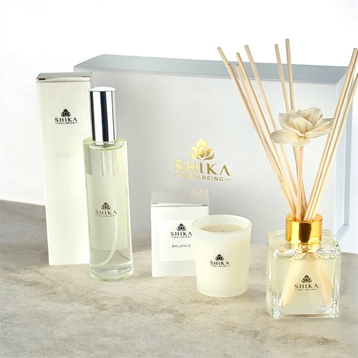 Shika diffuser, candle, and bottle on a light surface with a white background