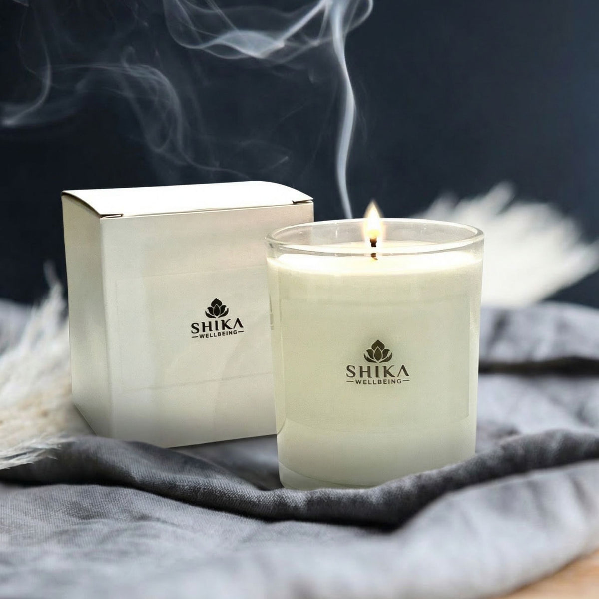 Shika Wellbeing candle and packaging on a textured surface with smoke effect