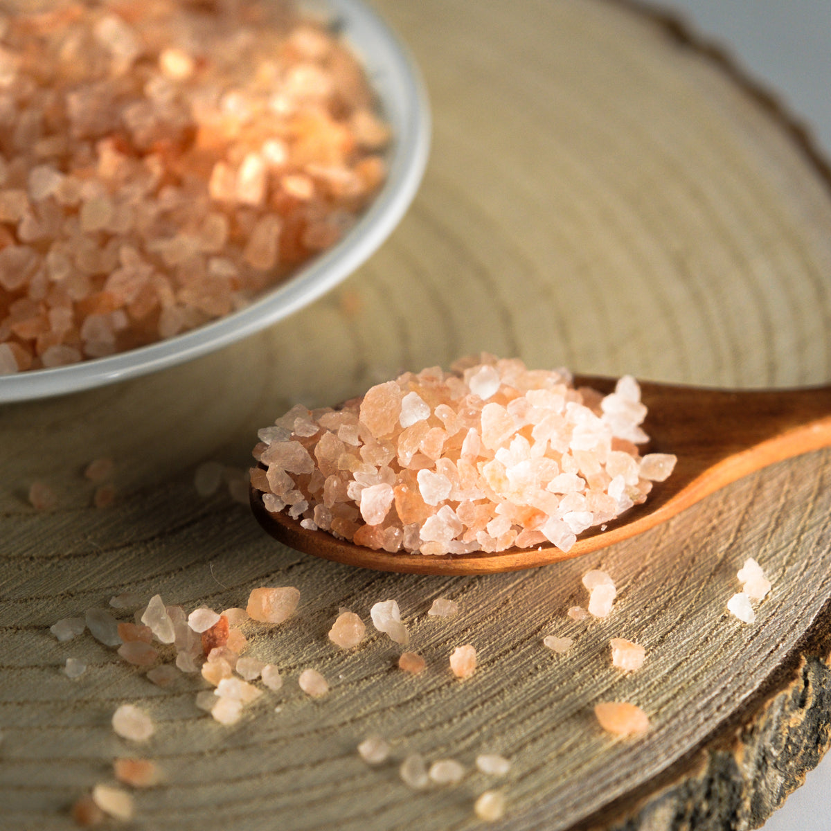 Pink himalayan salt on a wooden spoon and surface
