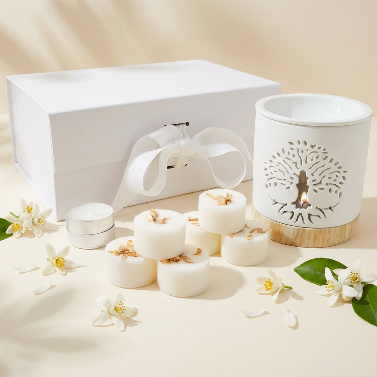 Set of white candles and a decorative lantern with floral design on a beige background