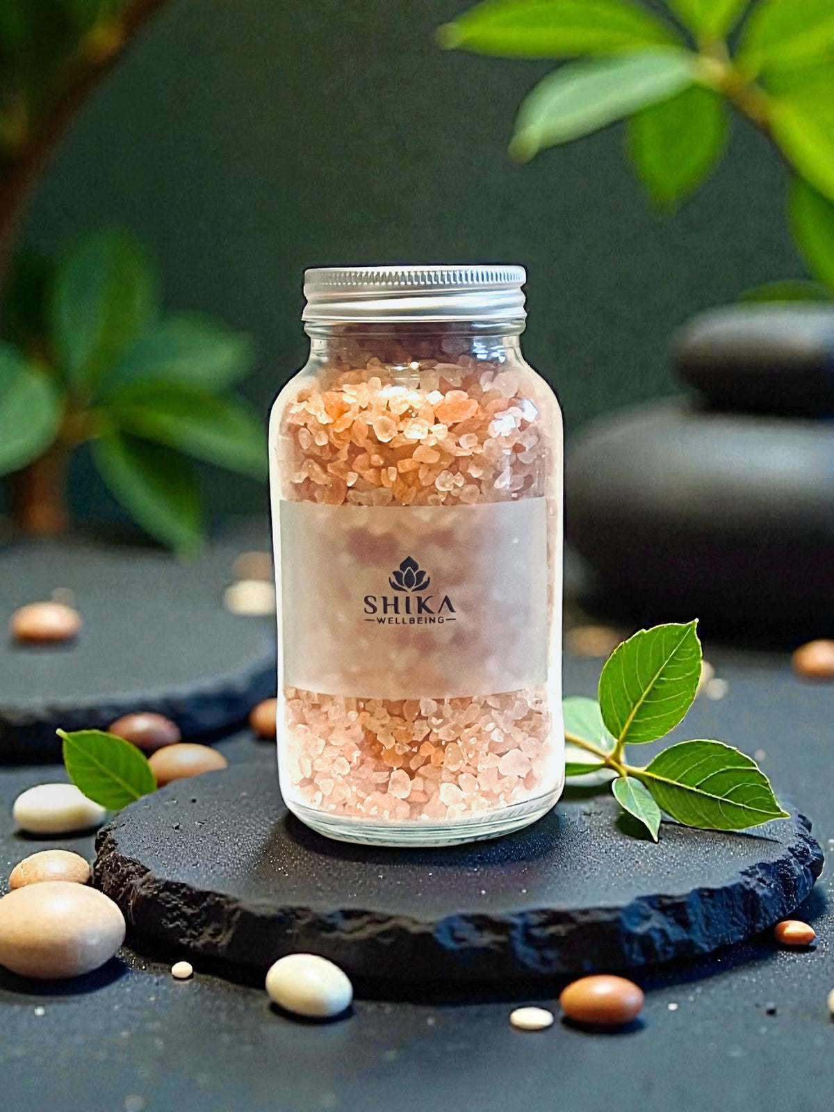 Bottle of Shika bath salts on a dark surface with green leaves