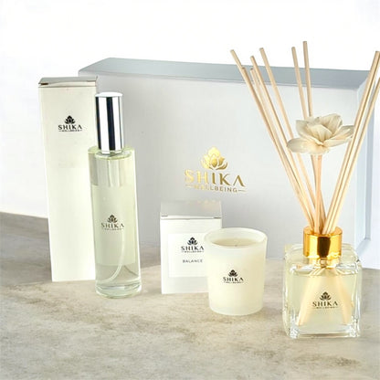 Shika diffuser, candle, and bottle on a light surface with a white background