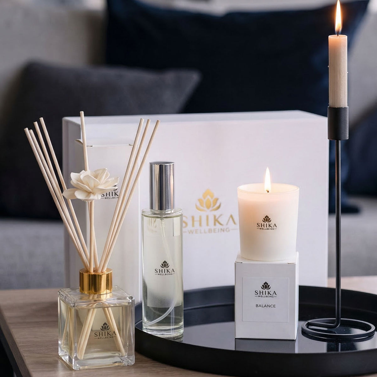 Shika diffuser, bottle, and candle on a table with a blurred background