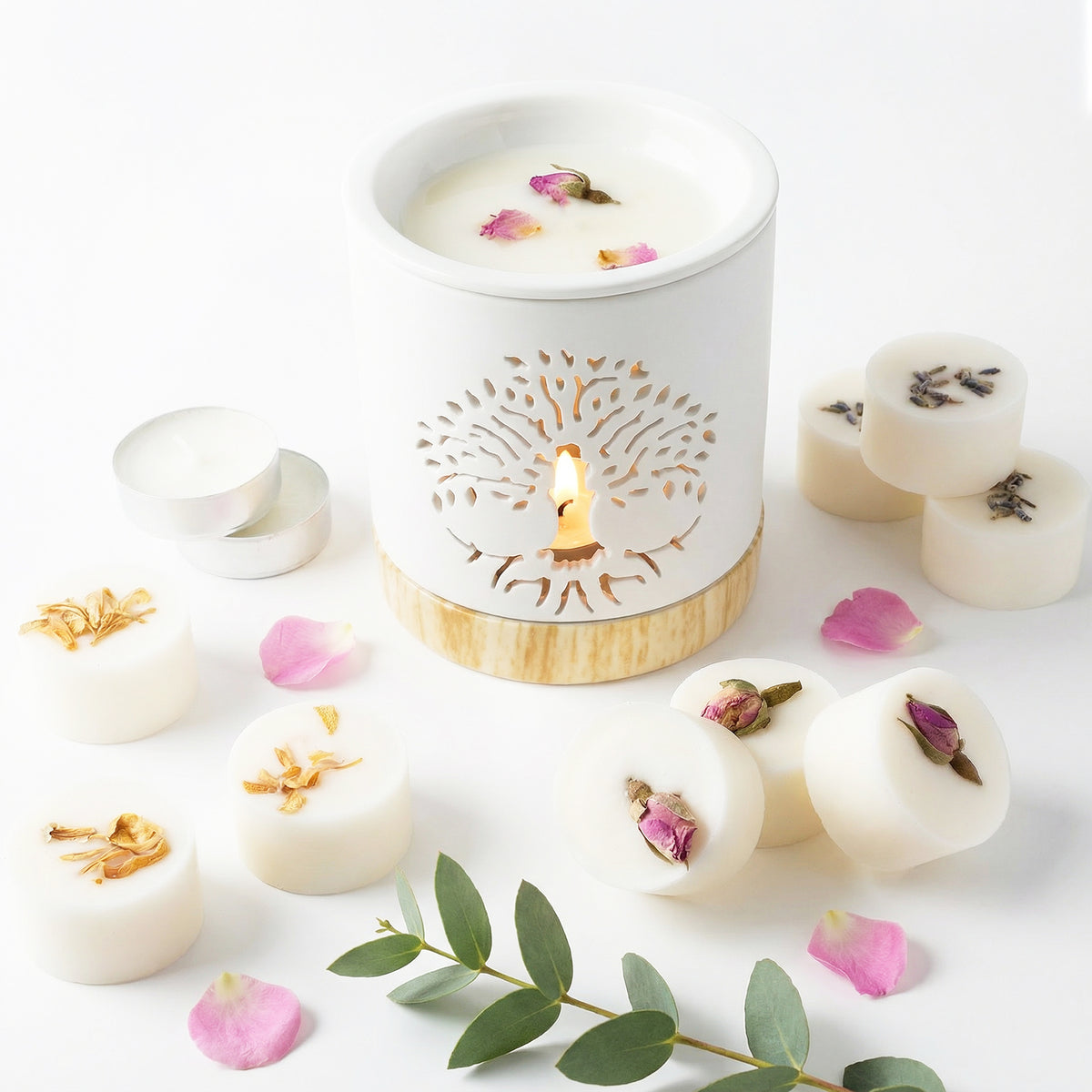White wax melts with floral petals and a decorative candle holder on a white background