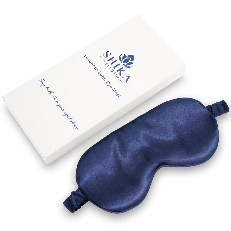 Blue satin eye mask with Shika Wellness packaging on a white background