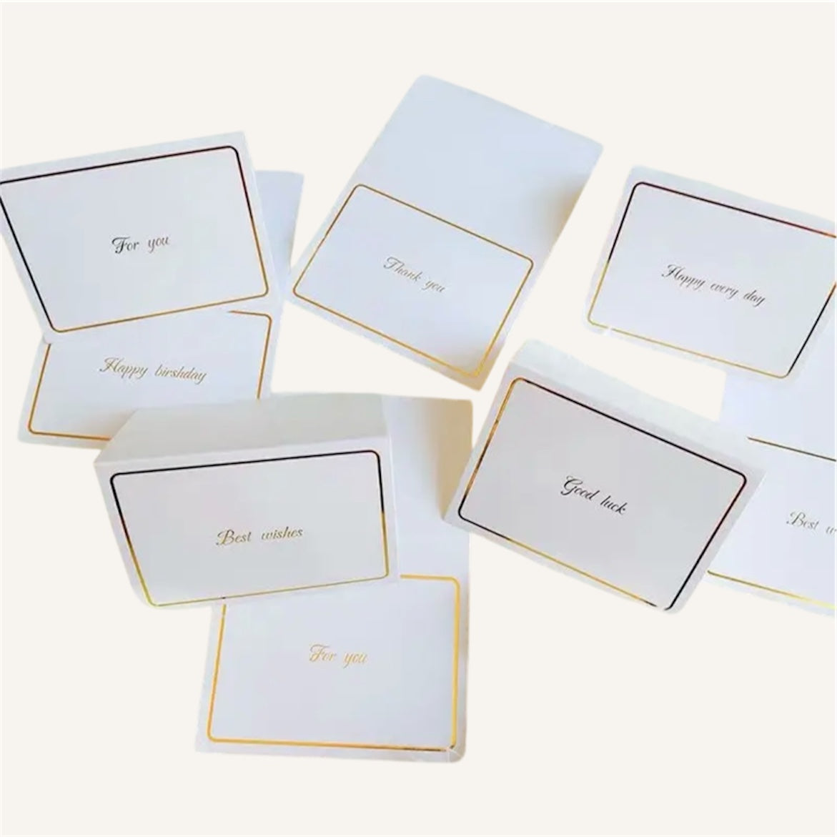Set of white cards with gold text on a white background