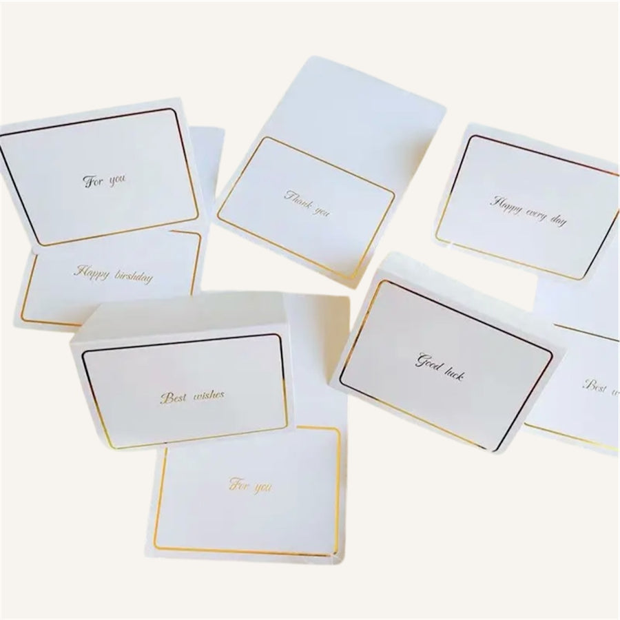 Set of white cards with gold text on a white background