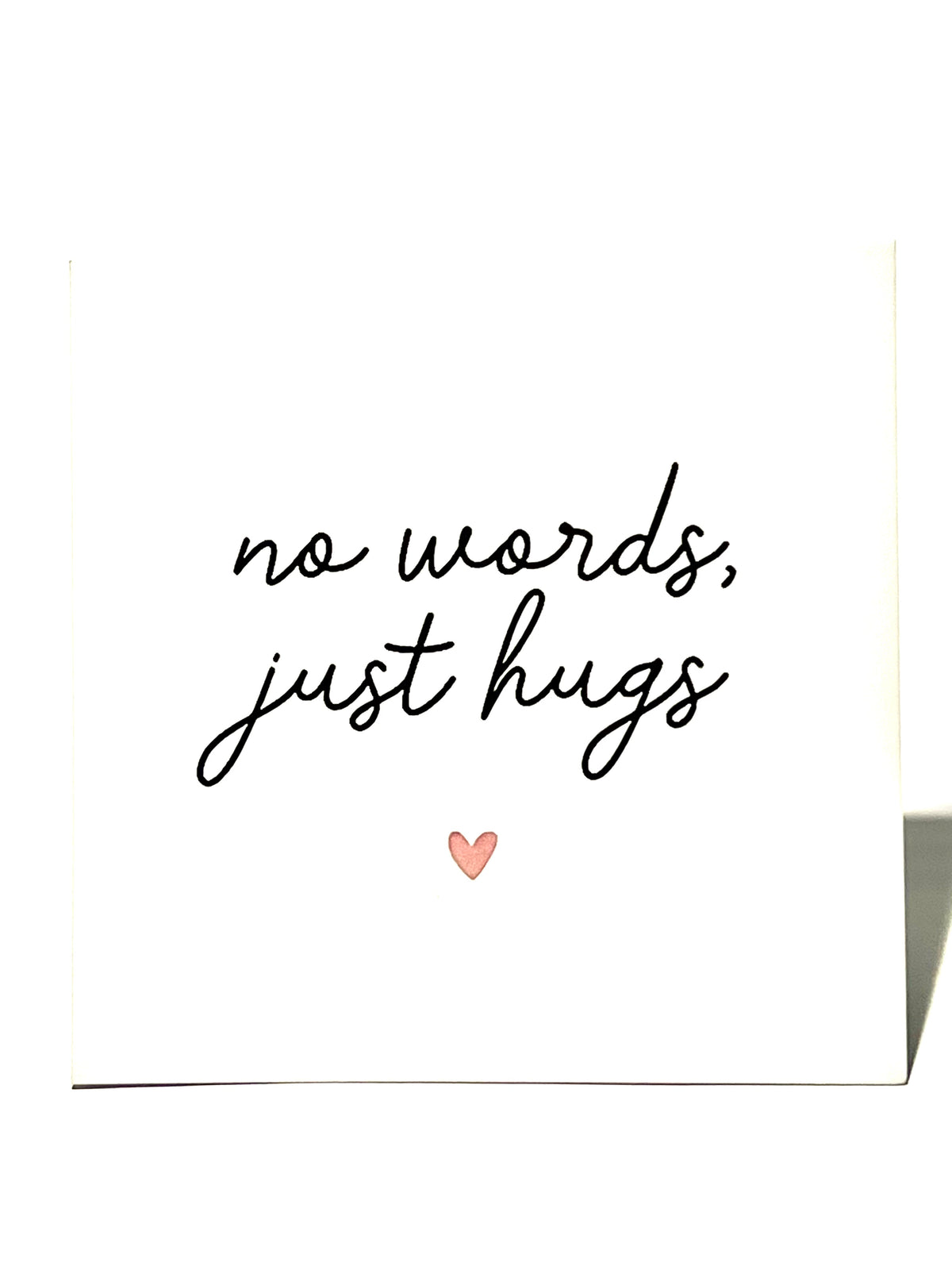 Card with 'no words, just hugs' text and a heart on a white background