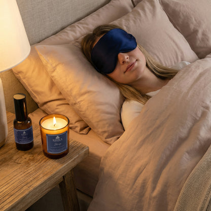 Woman sleeping in bed with a candle and bottle on the nightstand