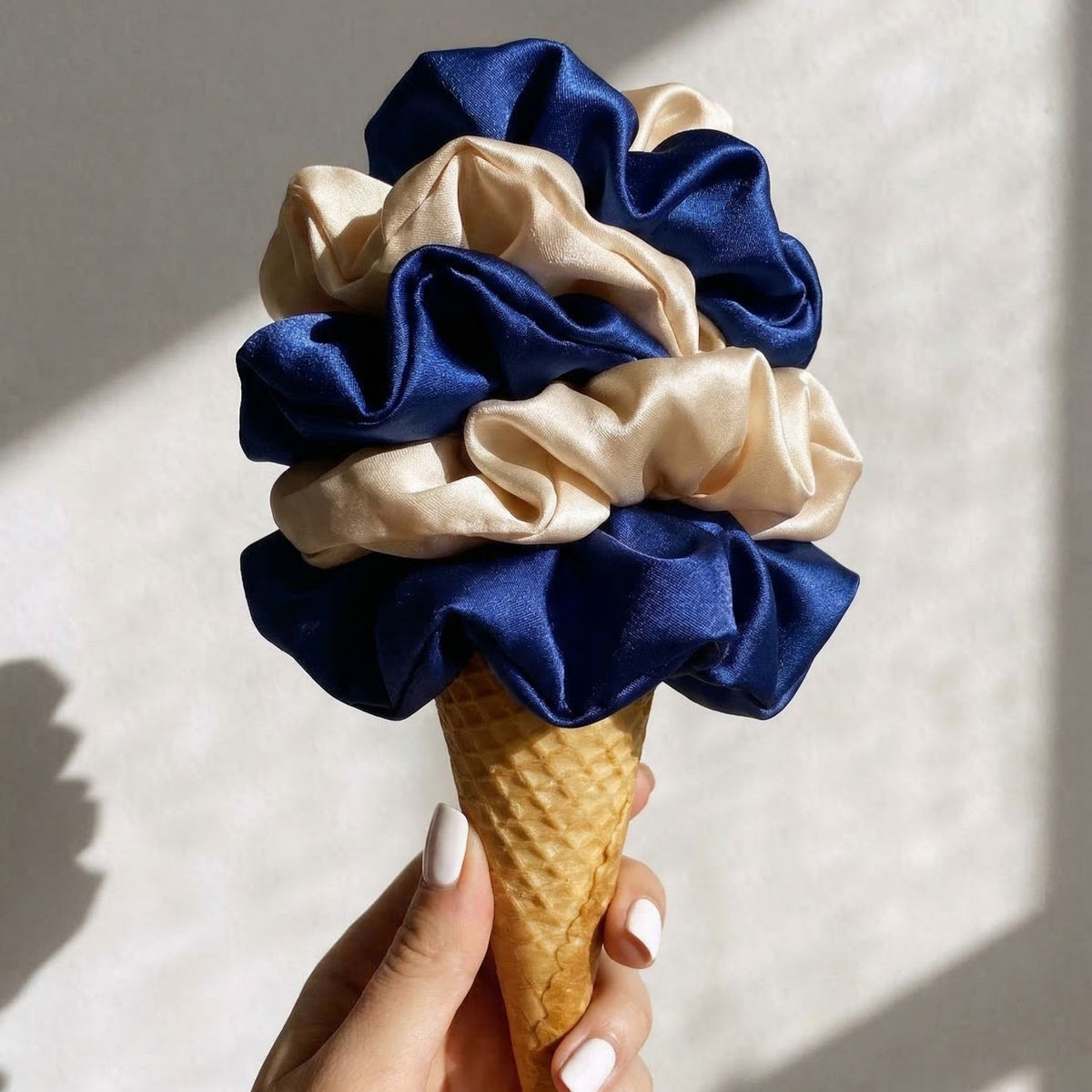 Ice cream cone with blue and beige fabric wrapped around it against a light background