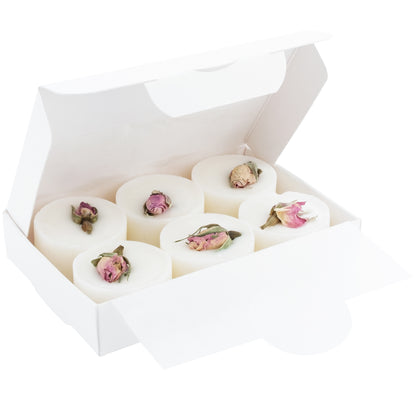 White soap bars with pink flower petals in a white box on a white background